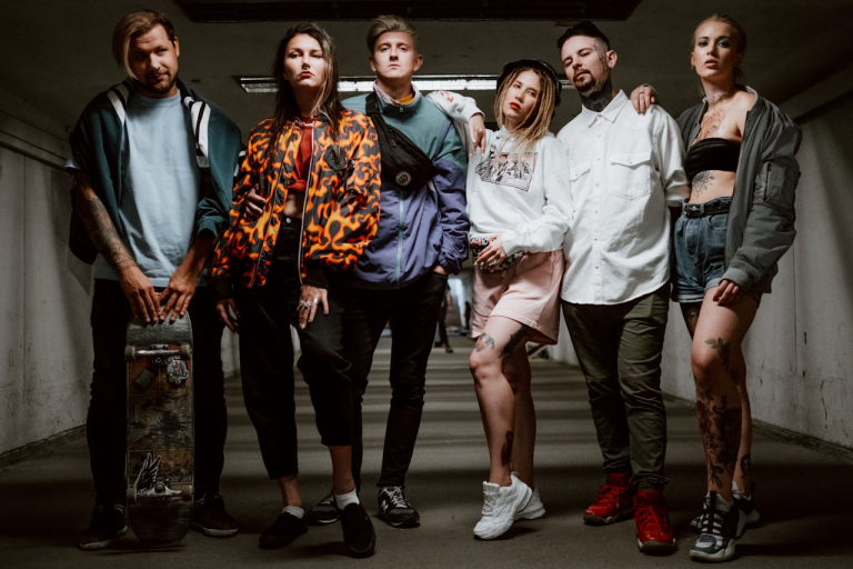 A diverse group of fashionable young adults posing in an urban underground tunnel, showcasing contemporary street style.